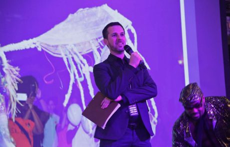 A person in a suit holds a microphone