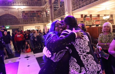 Two people hug in a Library