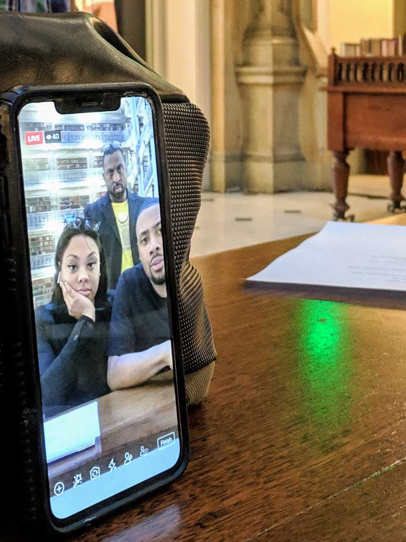 Advisory-Board-members-promote-the-ball Three people shown in a cell phone