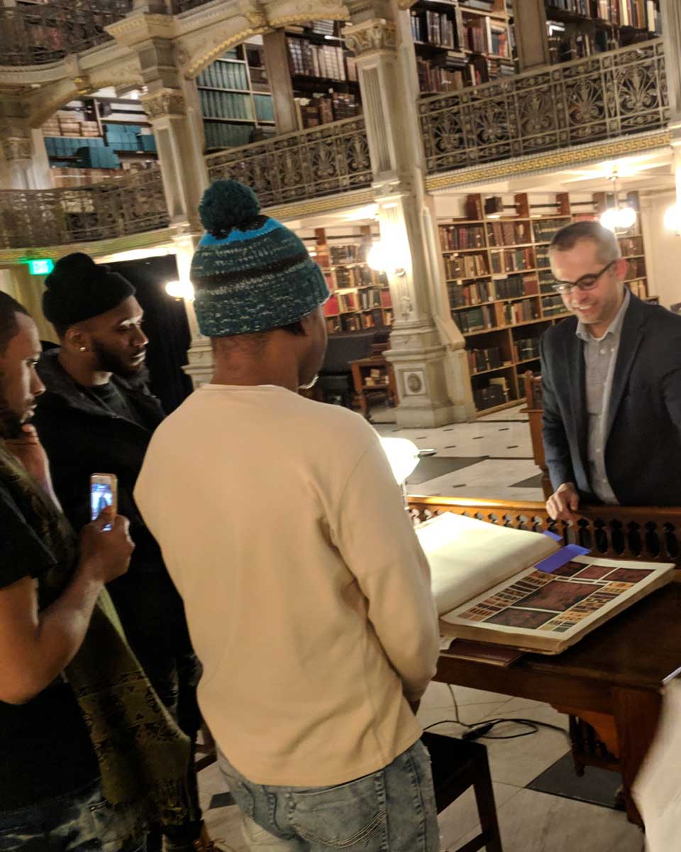 IMG_20190116_204318_med a person in a suit shows a book to a group of people