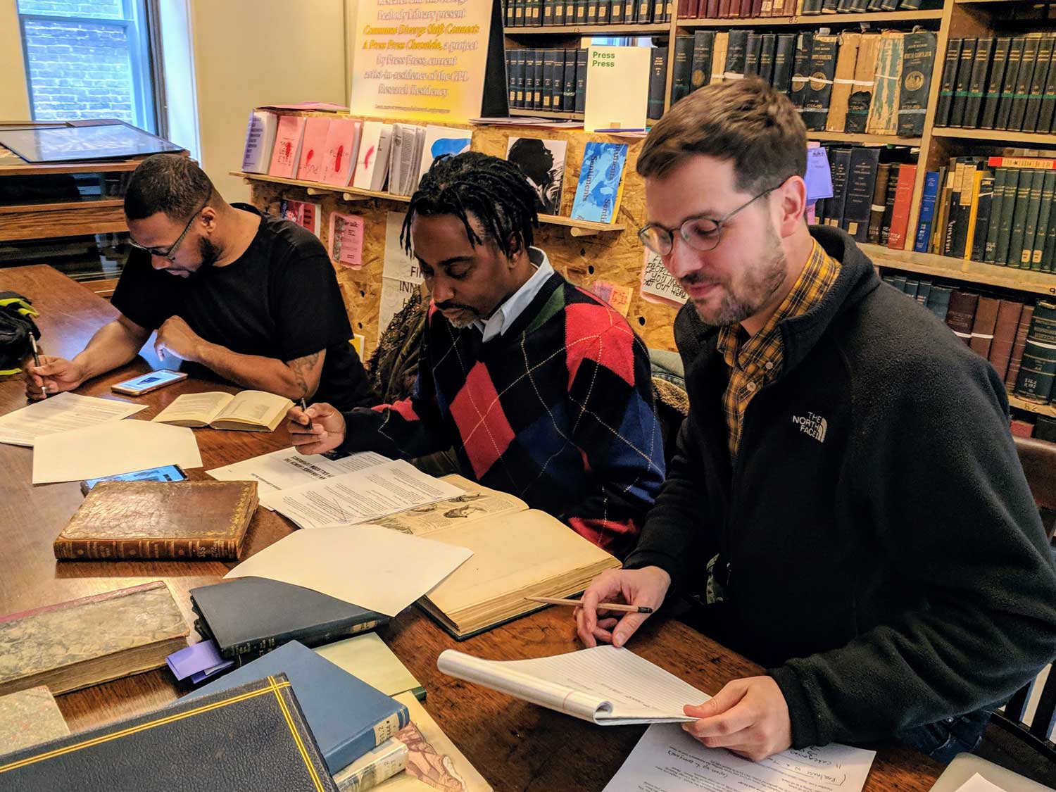 Joseph-Plaster_Advisory-Board three figures sit and research books