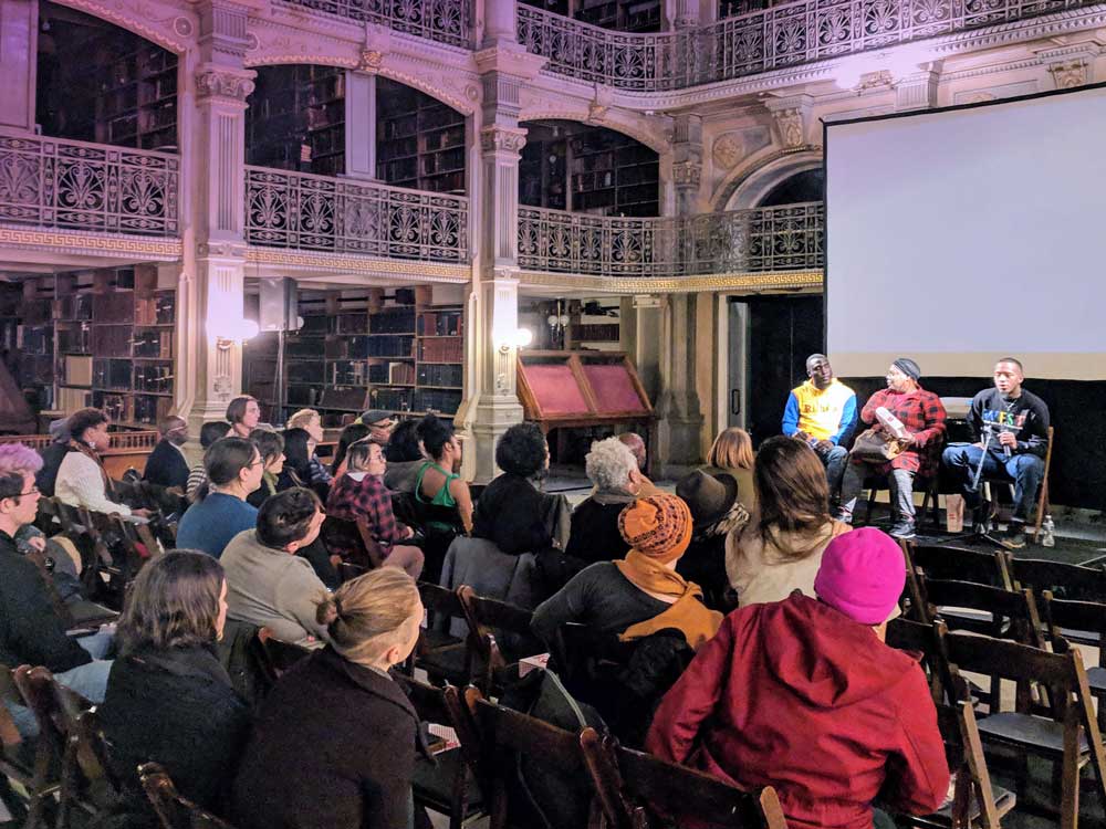 An audience in front of a panel at the George Peabody Library